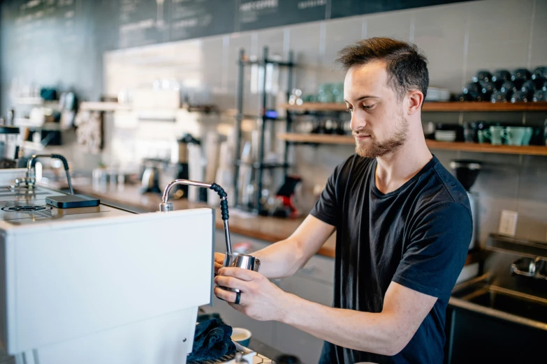 man filling up cup in small commercial kitchen