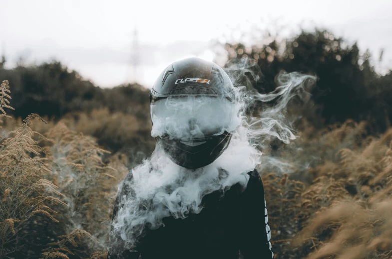 a man wearing a helmet and smoking a cigarette
