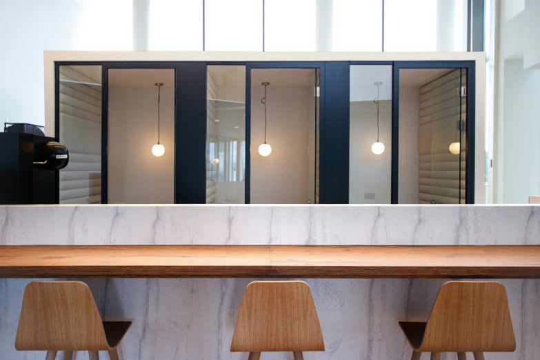 a counter with three stools in the middle and an elevator next to it