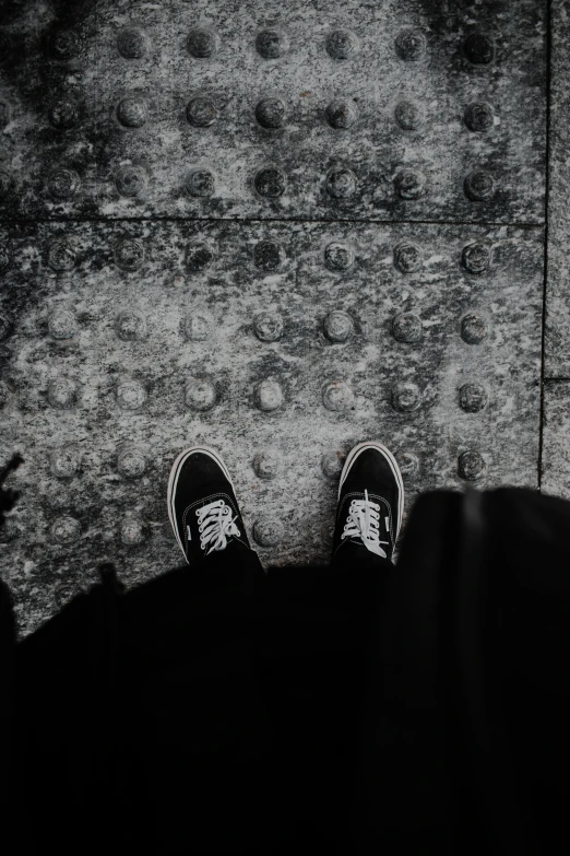 a person is sitting in the shadows and has his foot up against the wall