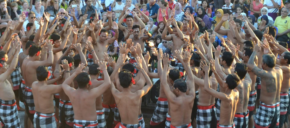 a large group of people in bathrobes, wearing towels and making the splits