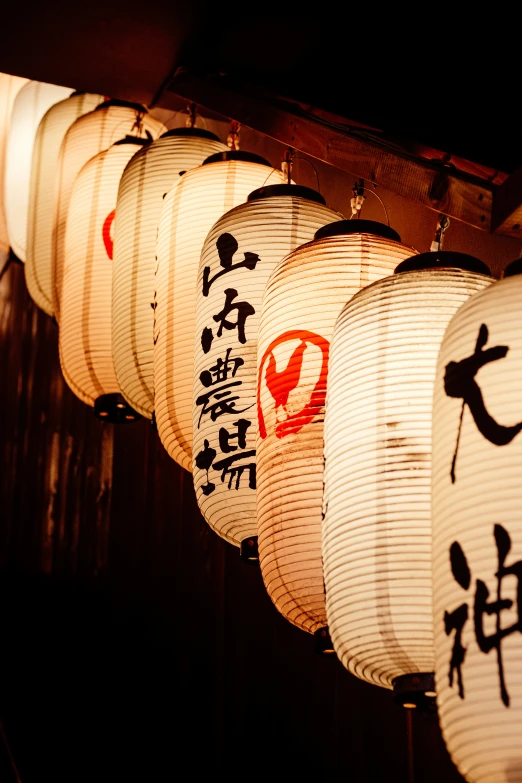 a group of lanterns hanging from a ceiling next to a building