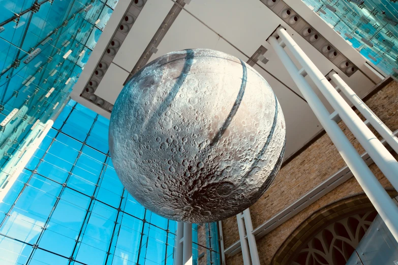 a metal ball in the middle of a glass building