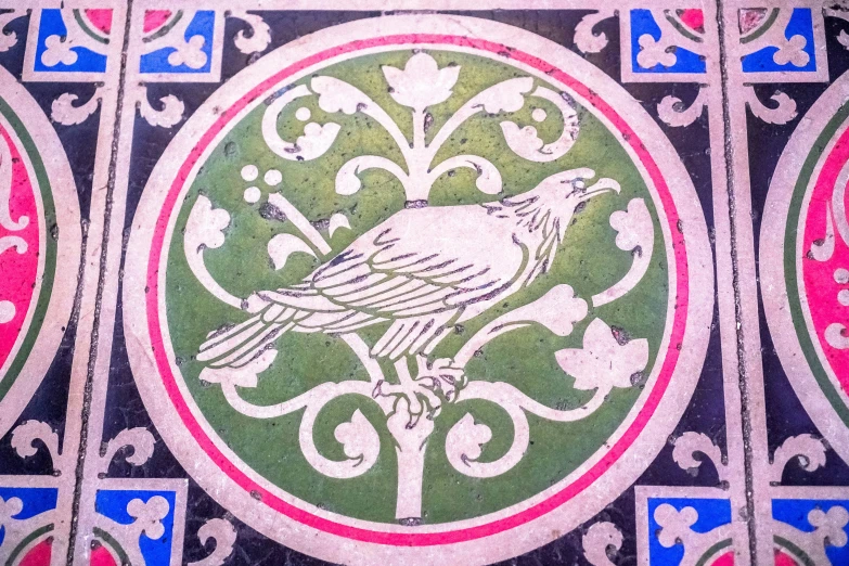 a colorful bird tile work in red, green, blue and pink