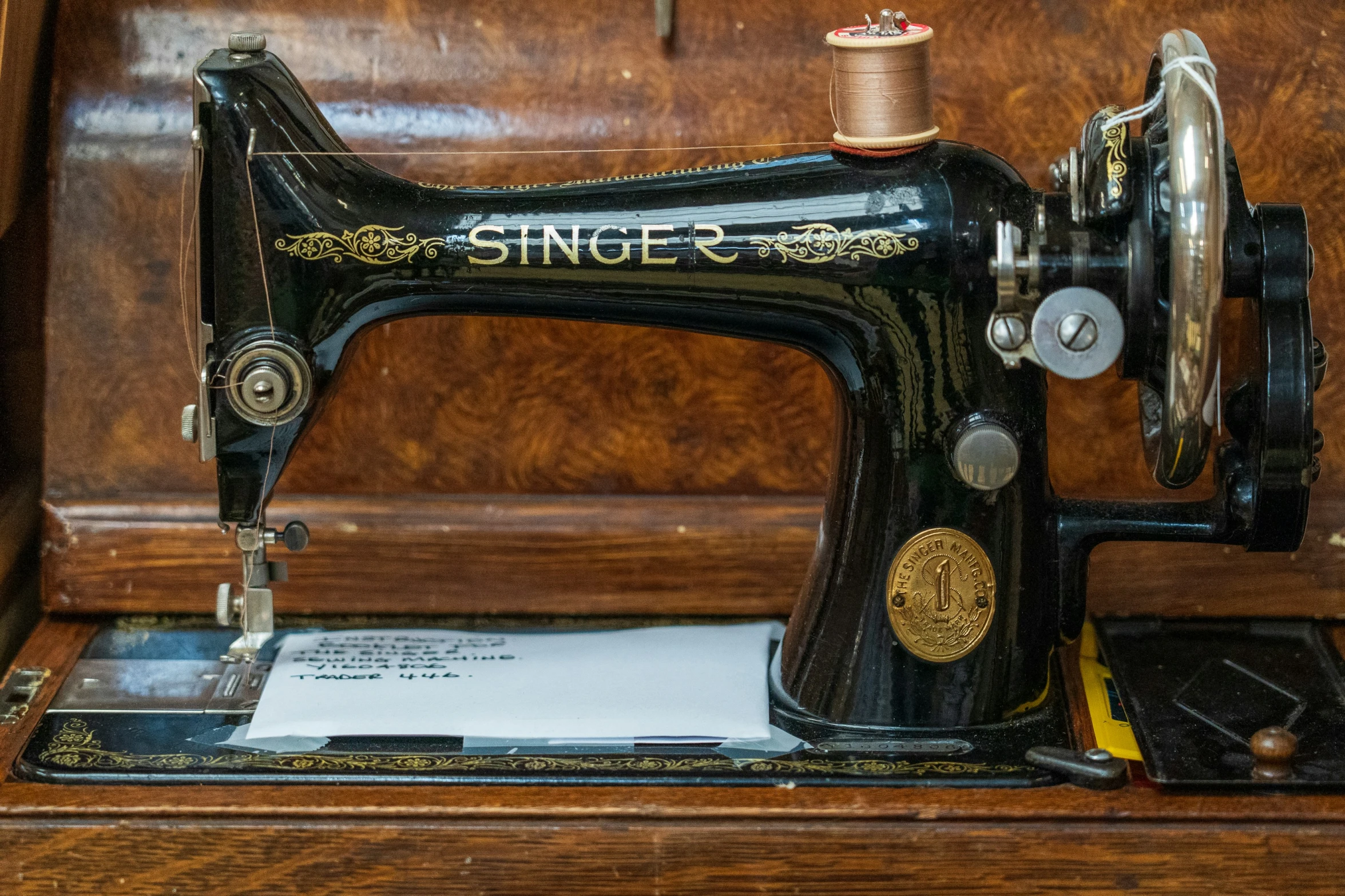 an old sewing machine is open with some paper