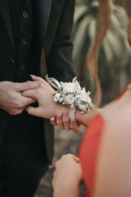 a person handing soing to a woman with a bouquet in their hand