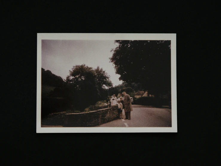 three people walking by some trees in the dark