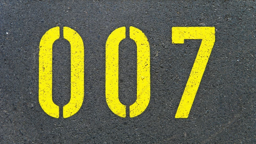 the number seventy in yellow is painted on a asphalt surface