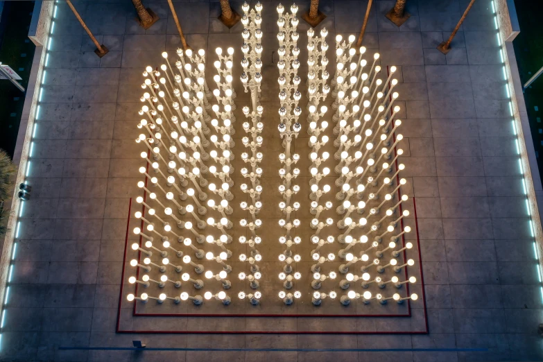 large sculpture made of lamps and light bulbs is pictured from above