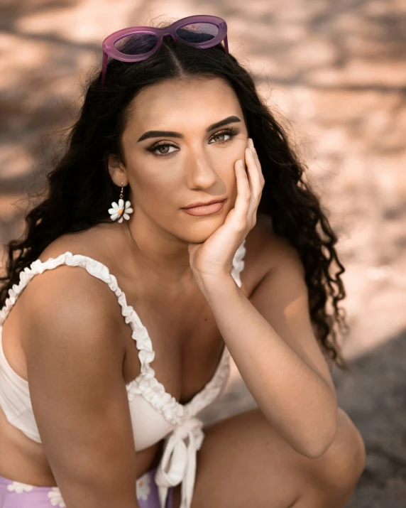 a girl in a bathing suit poses with sunglasses