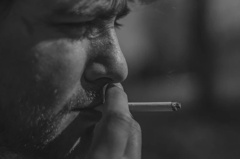 man with mustache and cigarette in black and white po