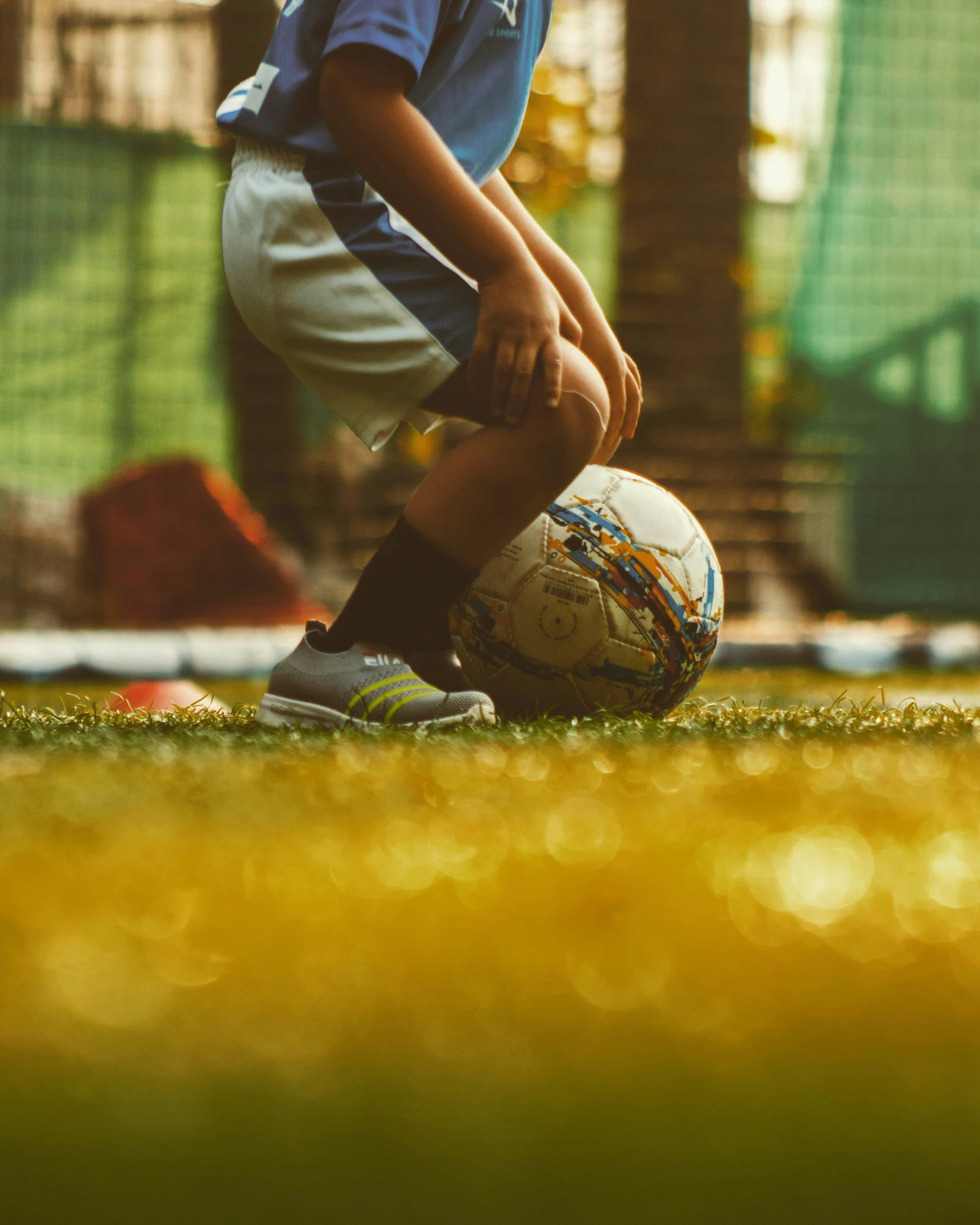 a  in blue shirt holding soccer ball