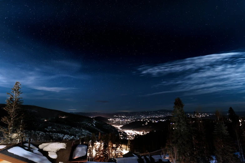 nighttime view of ski resort with city lite in background