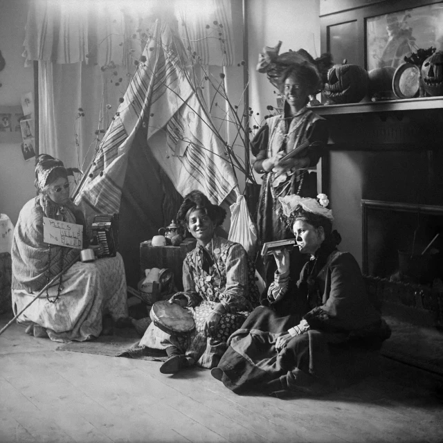 four ladies sitting on the floor around a tippa house