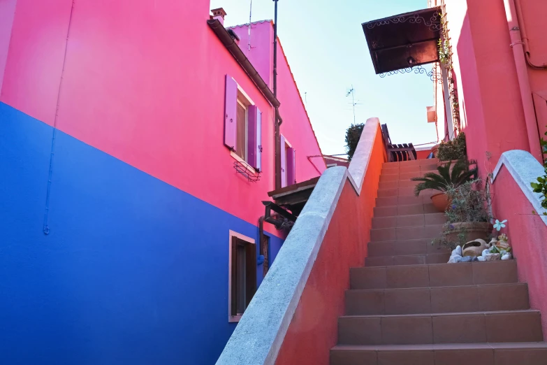 the stairs lead up to the bottom of a pink building