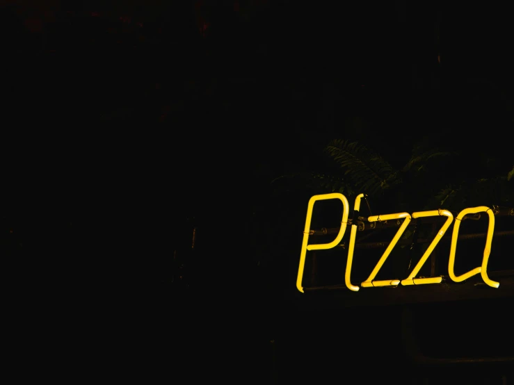 a neon sign with the word pizza spelled in yellow