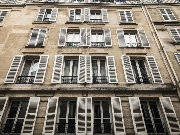 a tall building with several windows and shutters