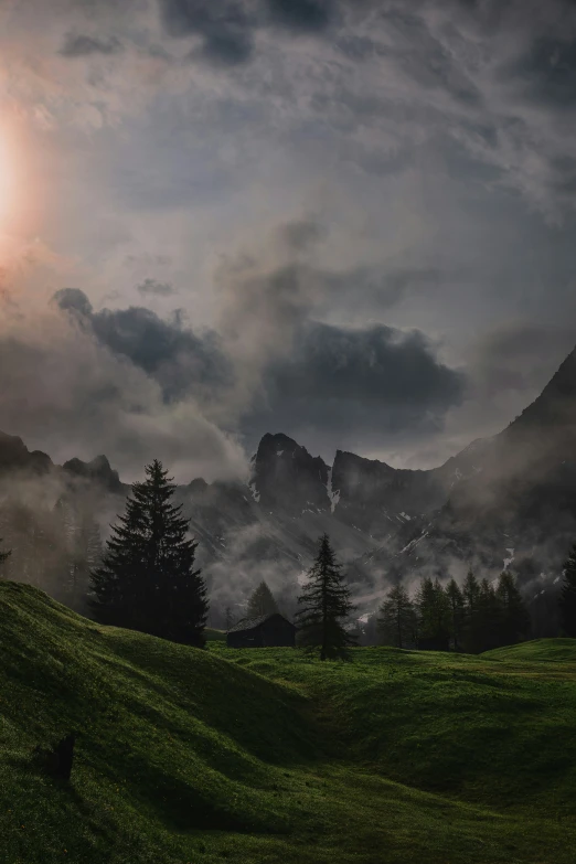 clouds over trees on a hillside near mountains