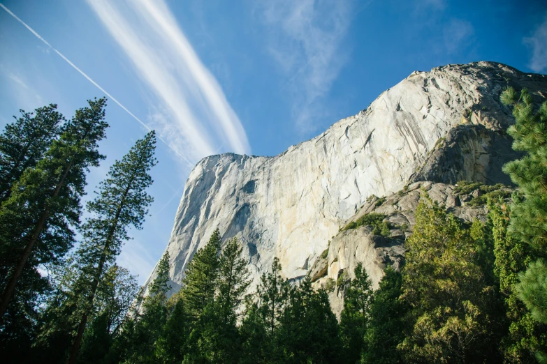 a tall mountain peak with clouds passing over it