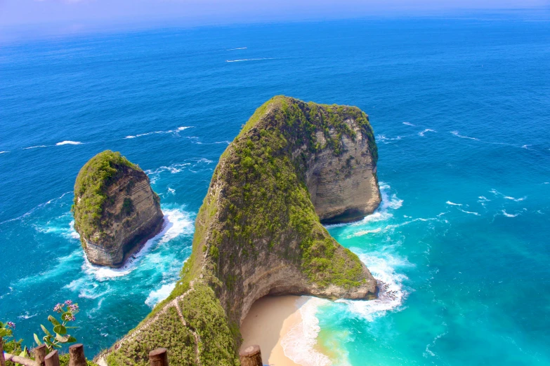 two rock formation on the ocean with water surrounding them