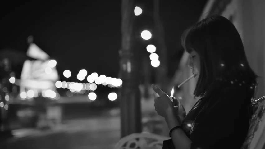 woman is smoking outside while looking at her phone