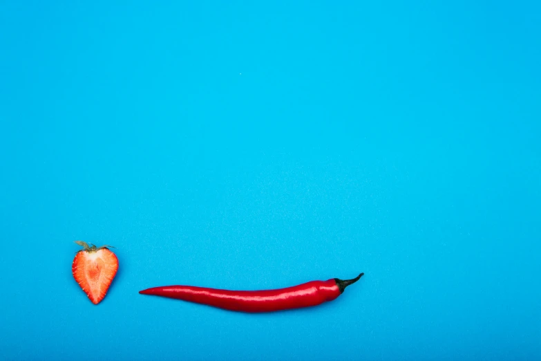 a red  pepper and a red pepper on a blue surface