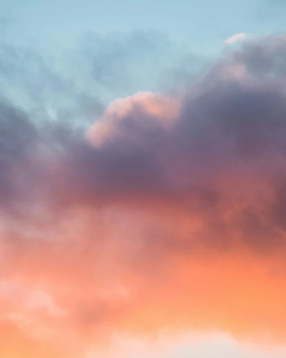 an orange colored sky with a plane coming in for landing