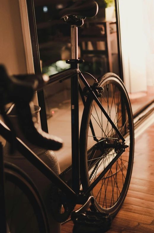 a bicycle locked up to the front wheel of a bus