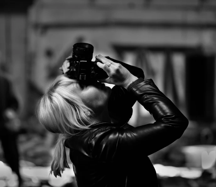 a woman takes a po in the city with a camera
