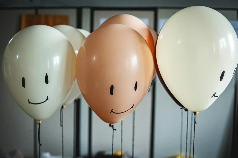 three balloons with faces in the center of them