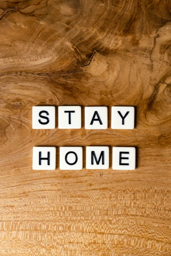 the word stay home spelled with wooden letters