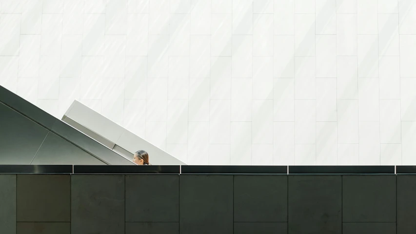 an escalator sits in front of a wall with lots of white tile