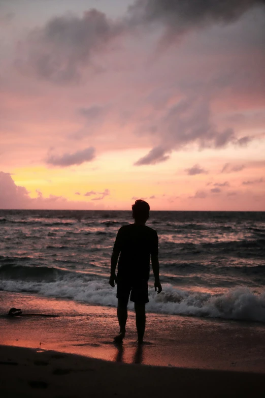 a man standing on a beach next to the ocean