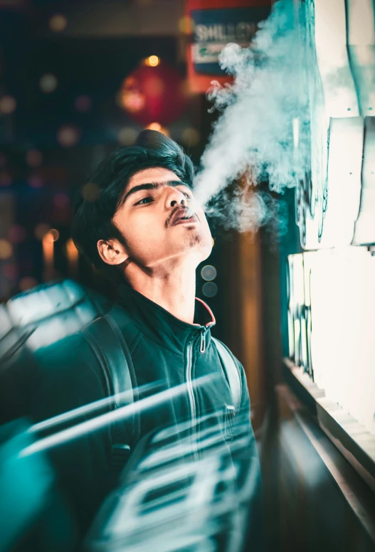 a man wearing headphones smokes an electronic device on the wall