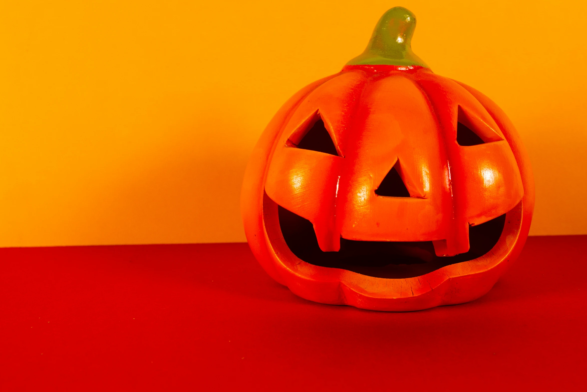 an evil pumpkin in front of a bright yellow wall