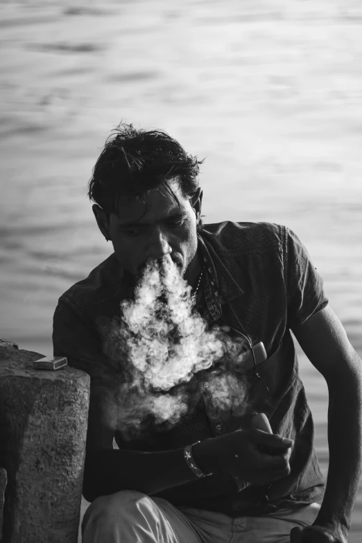 a man smoking soing in a cigarette outside