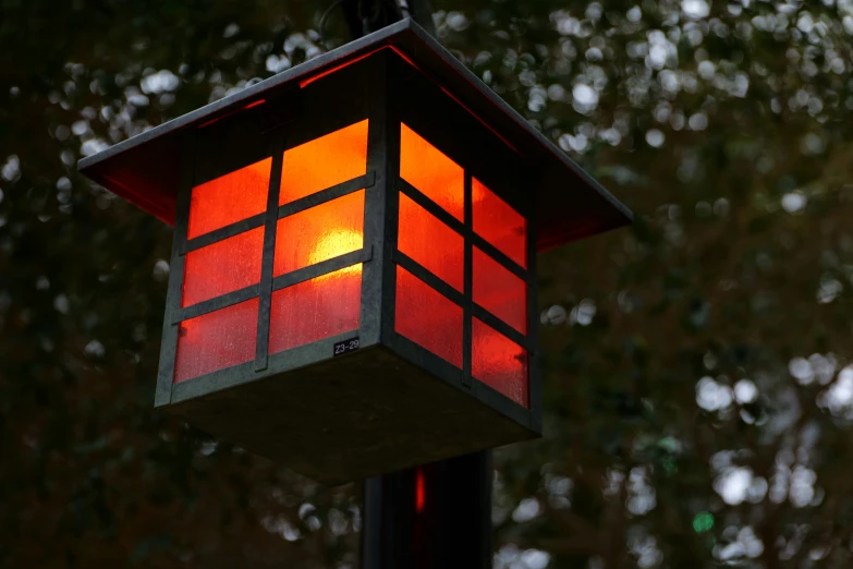 an orange and red lantern is attached to a pole