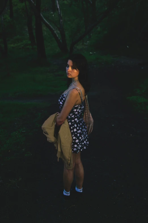 a woman standing in the forest looking up at soing