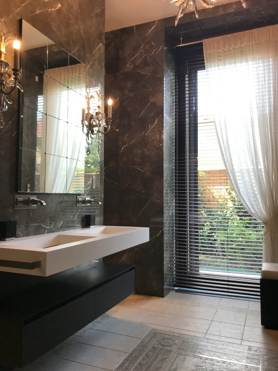 a bathroom with dark marble tiles and white floor