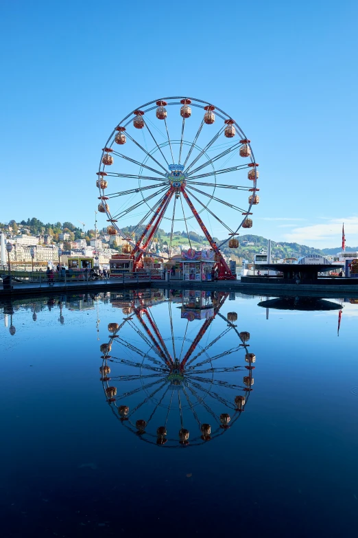 an amut park ferris wheel reflecting in the water