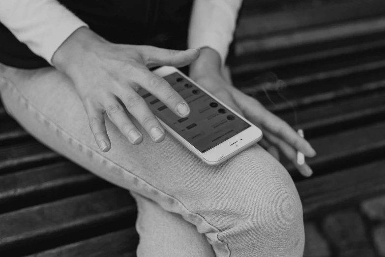 a black and white po shows someone's hand resting on their phone