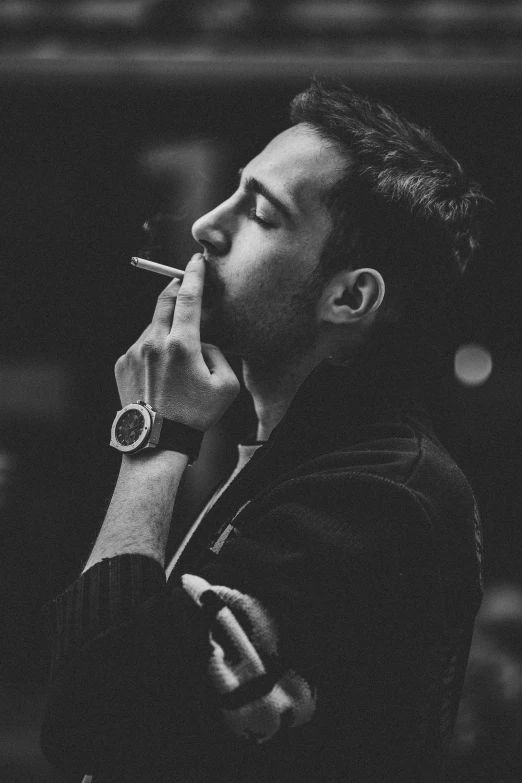 man smoking a cigarette with both hands in his mouth