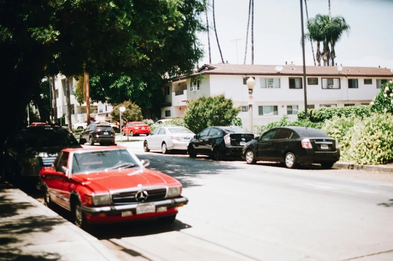 a red car is parked on a street corner