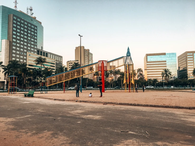 an empty playground with people standing around it