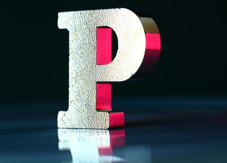 a wooden letter is standing on a reflective surface