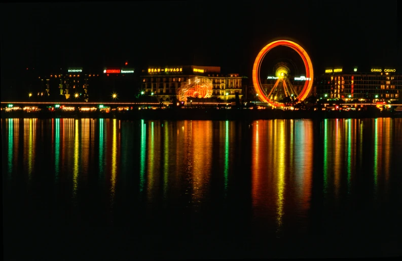 the ferris wheel is brightly lit up by the lights of others