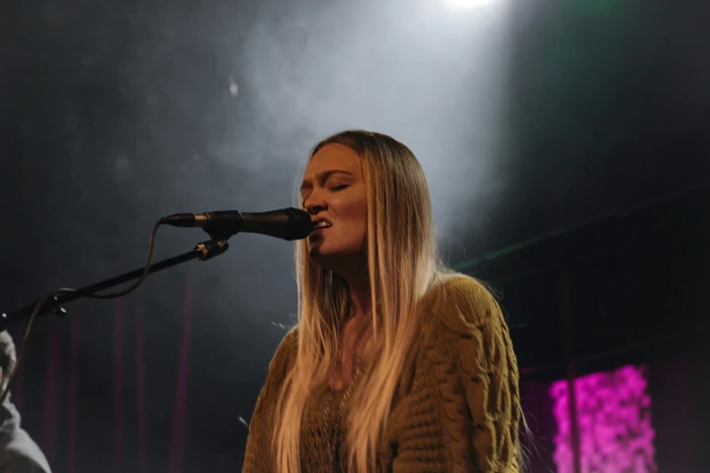 a woman that is singing into a microphone