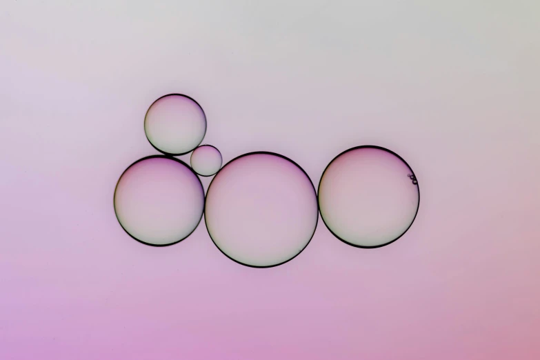 the three glass bubbles are on a pink and purple background