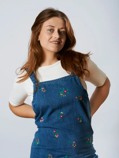 a woman in blue overalls and white t - shirt