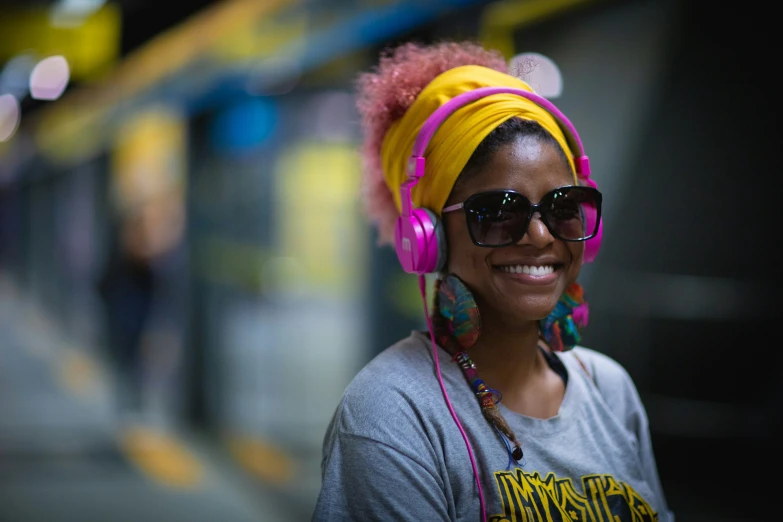 a black woman with pink headphones and a yellow ear muff